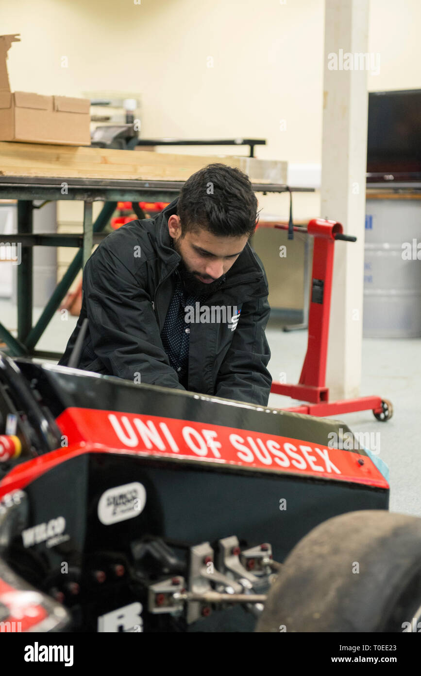 A young international muslim student woking on a racing motorsport cart in the mechanical engineering department of the University of Sussex Stock Photo