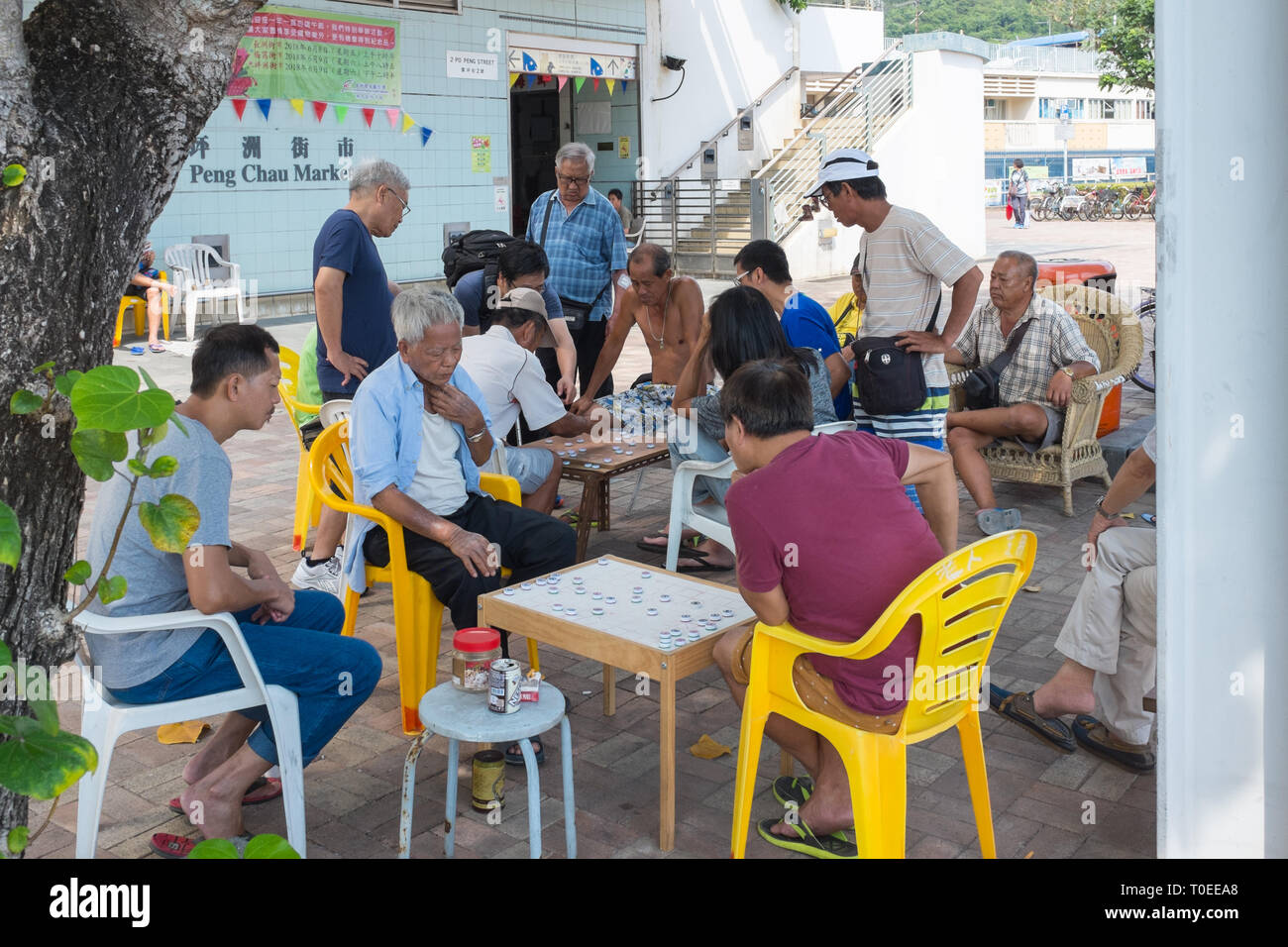 Group of men playing a board game outdoors on the small Hong Kong