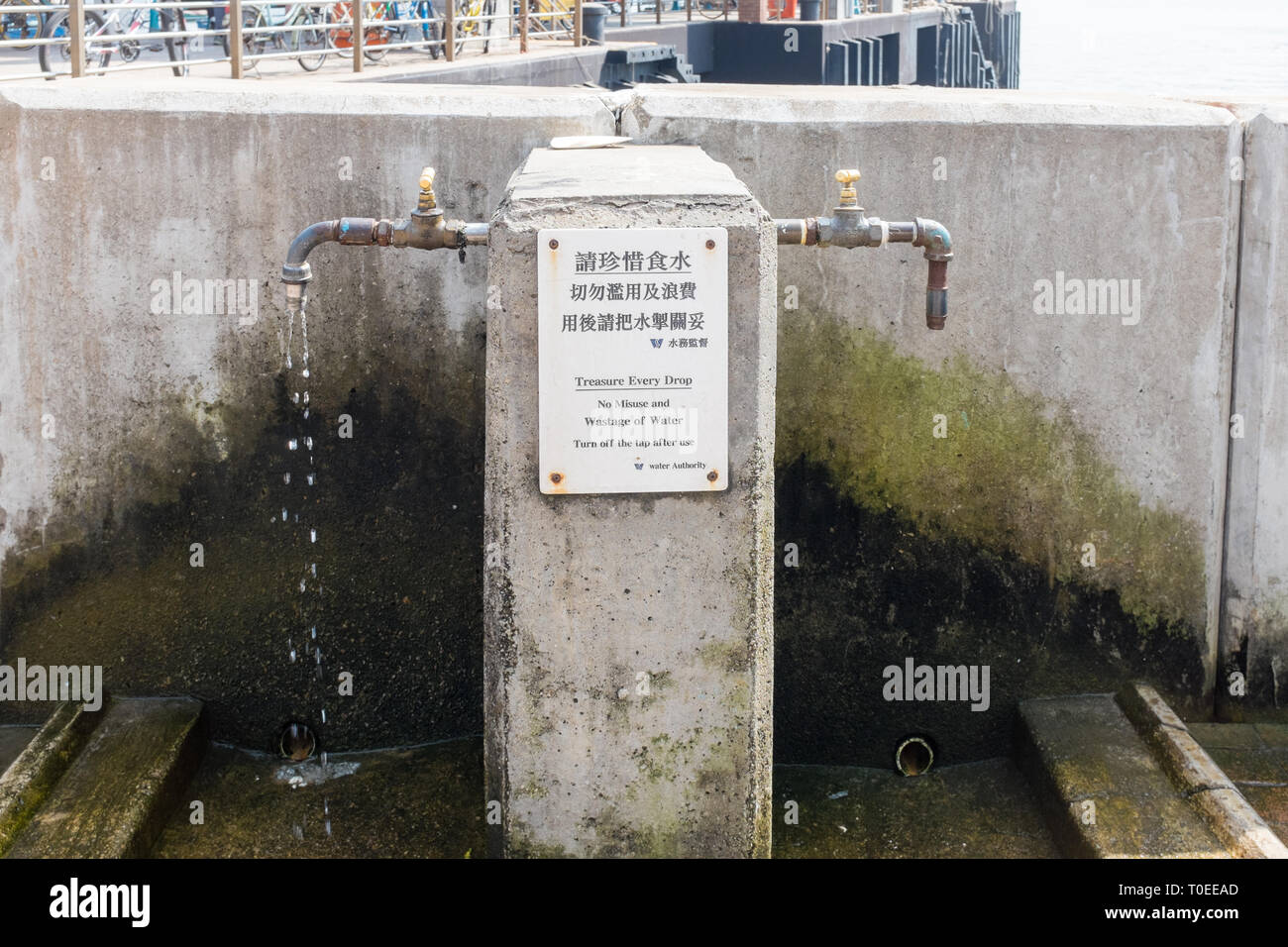 Public drinking water taps on the small Hong Kong island of Peng Chau with warning not to waste water and turn off the tap Stock Photo