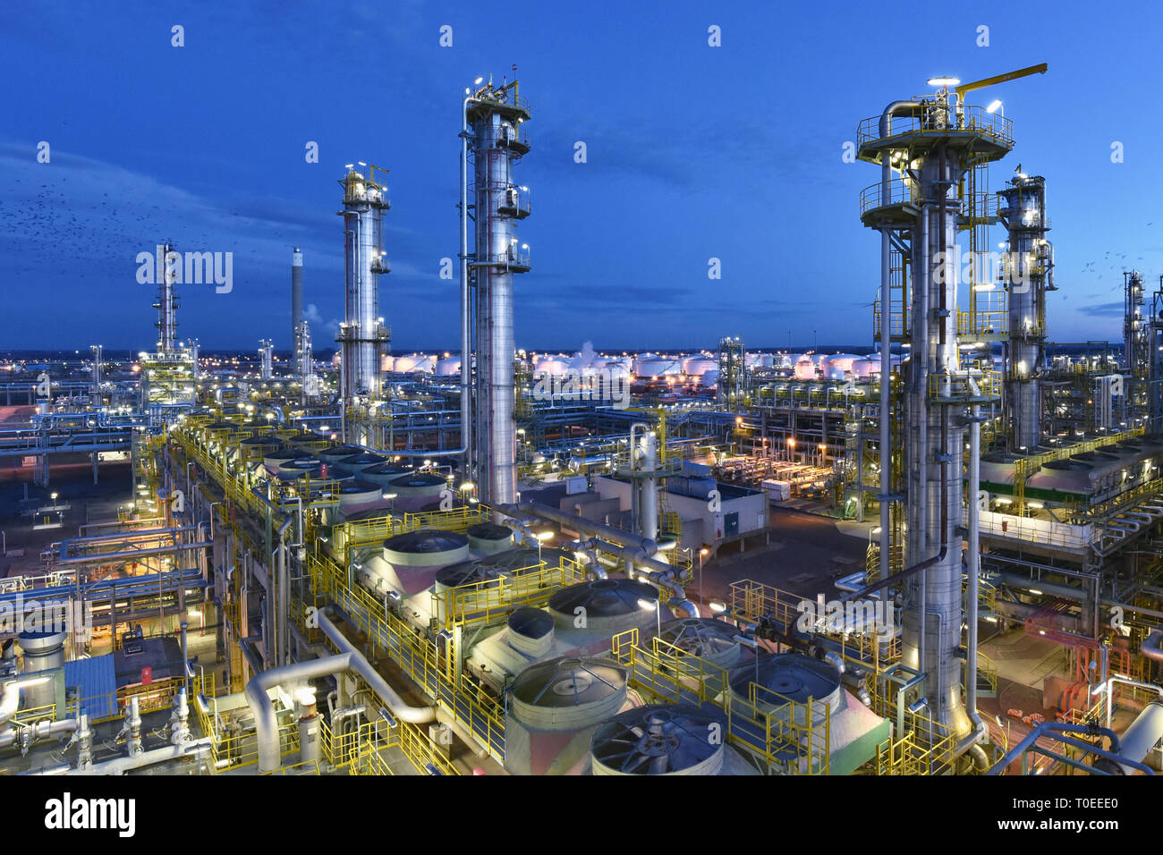 refinery - chemical factory at night with buildings, pipelines and lighting - industrial plant Stock Photo