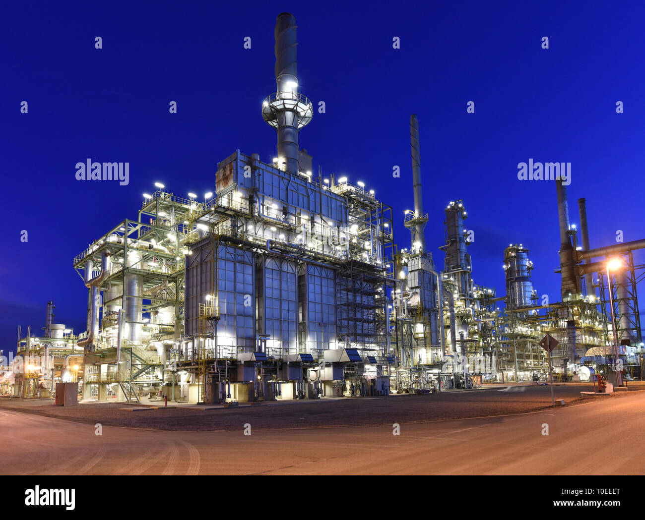refinery - chemical factory at night with buildings, pipelines and lighting - industrial plant Stock Photo