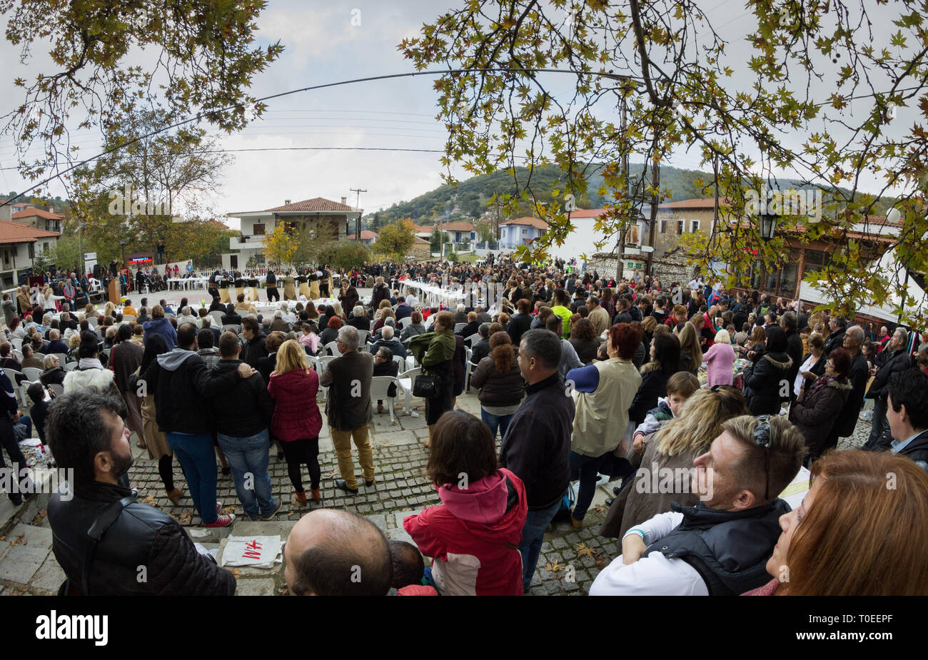 Crowds attending Livadi's annual chestnut roasting festival and the folk dance groups performing live seen afar. Livadi,Thessaloniki, Thessaly, Greece Stock Photo