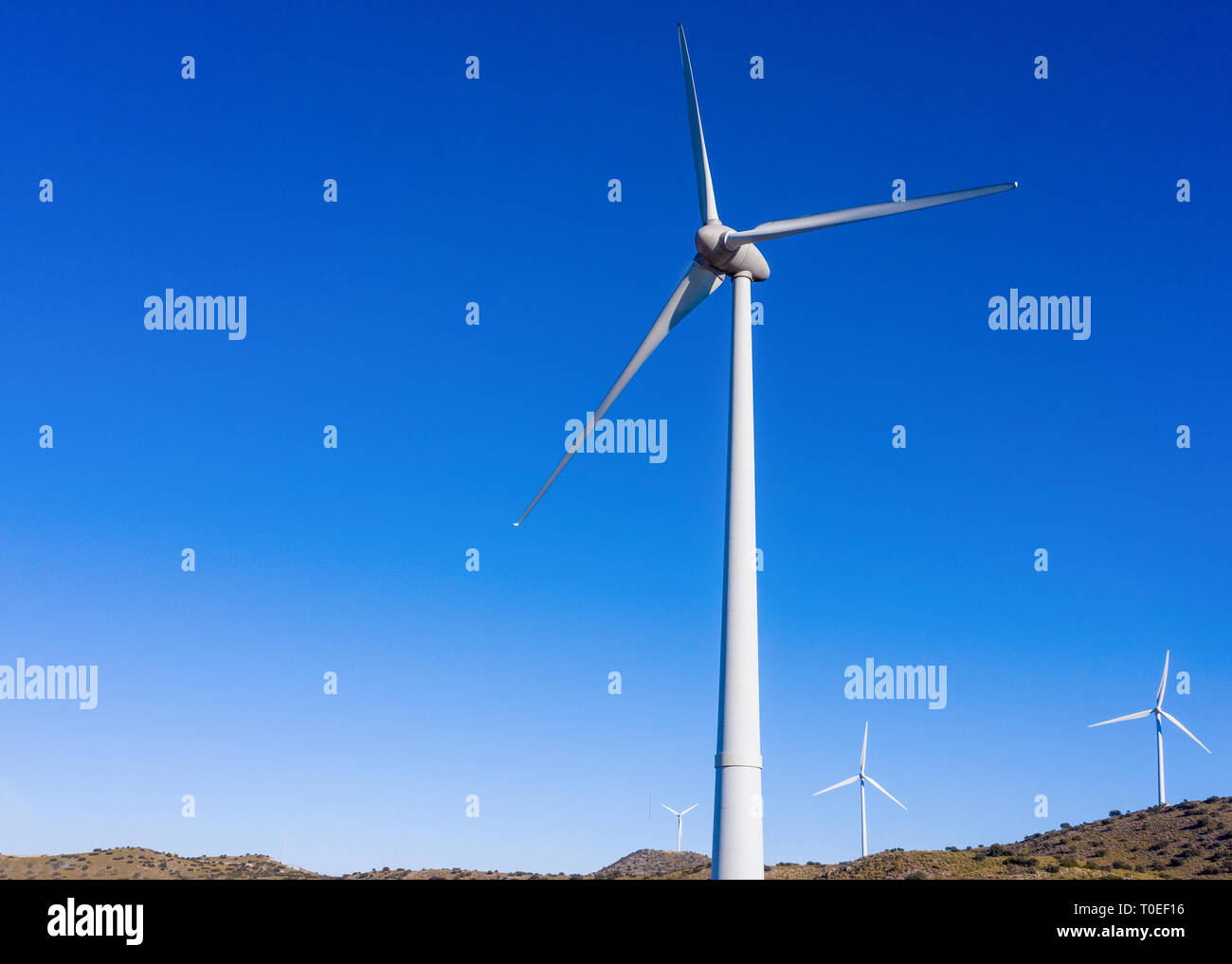 close up image  of group a wind  turbine with a plain blue sky background  for copy space shot from above Stock Photo