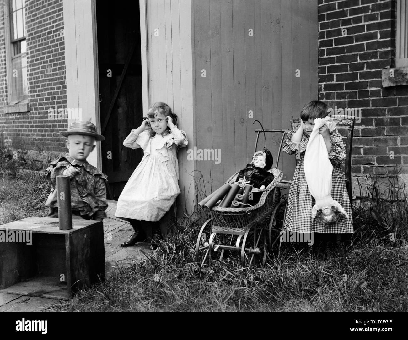 In an apparent set up comic photo, the children prepare to set off some dynamite for some good, clean fun, ca. 1900 Stock Photo