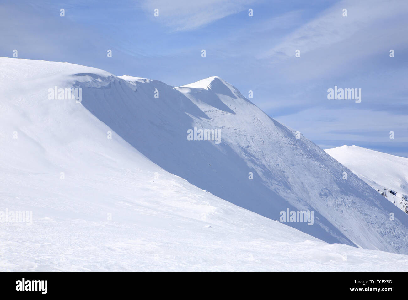 The mountains are covered with snow under a bright blue sky Stock Photo ...