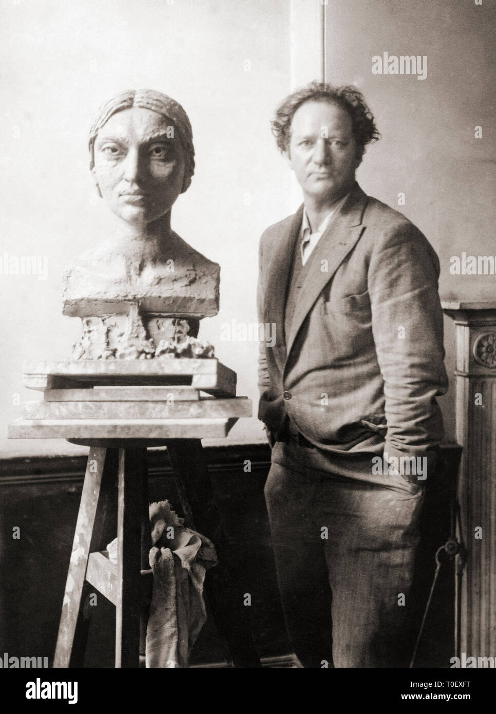EDITORIAL  Sir Jacob Epstein, 1880-1959.  American born English sculptor seen here with a bust he was working on in the 1920’s of Kashmirian model Sunita Devi, c. 1897-1932 Stock Photo