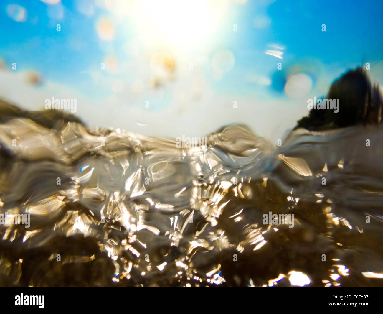 Blurred ocean wave half underwater - Out of focus sea wave underwater crushing on camera lens - Abstract background of salt water Stock Photo