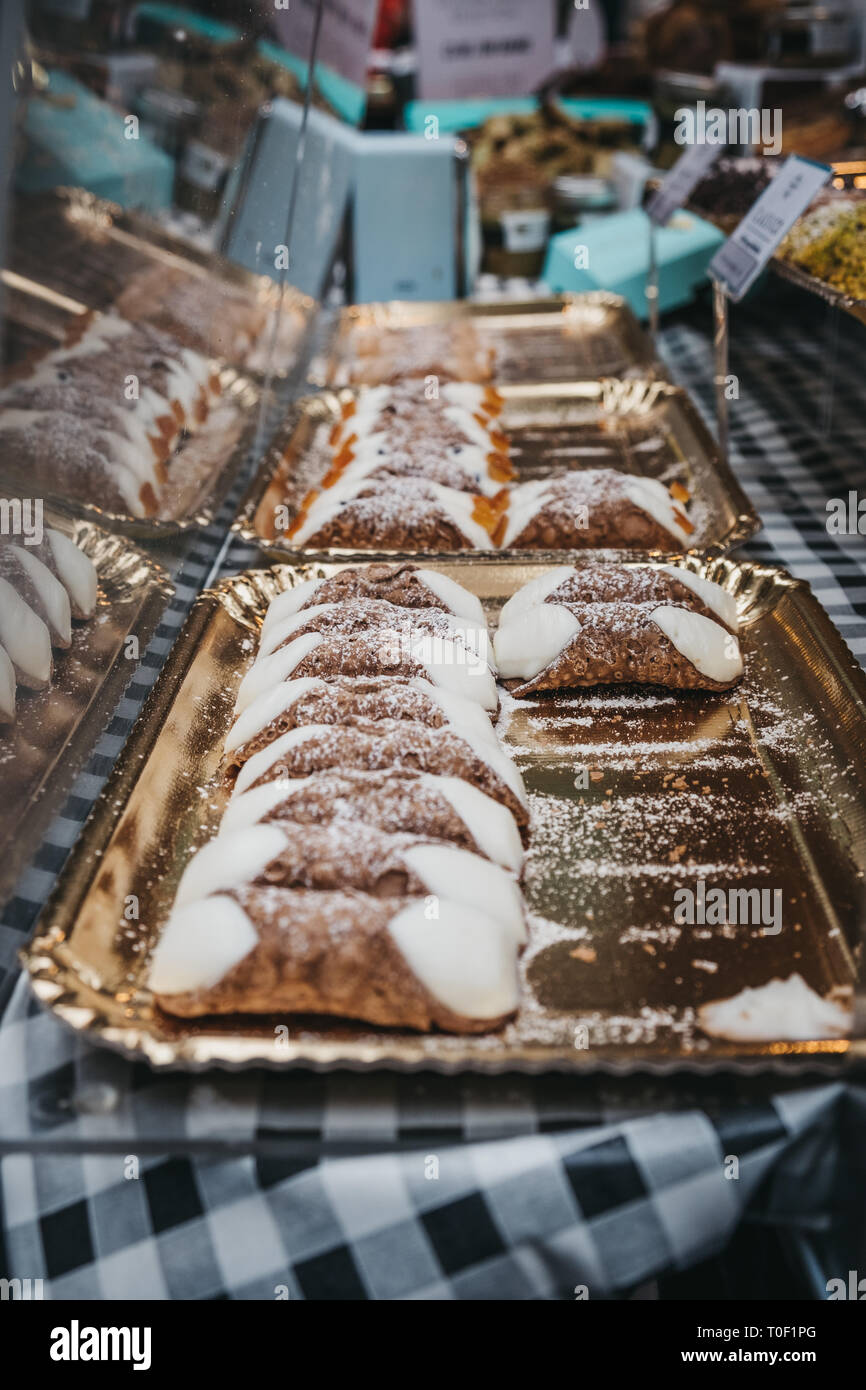 Fresh Italian Sicilian dessert cannolli ('Cannolo Siciliano') on sale at a market. Stock Photo