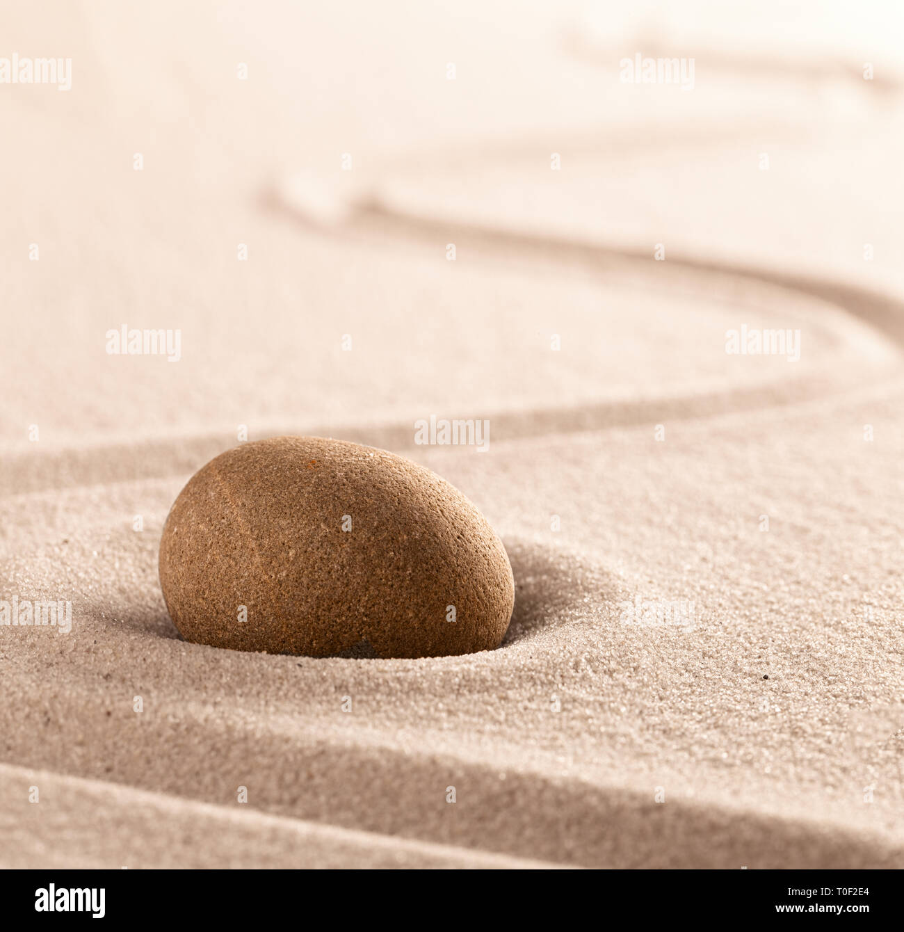 Yoga or zen Buddhism stone and sand background. Concentration or focus point for spiritual balance and purity of mind and soul. Sandy background with  Stock Photo