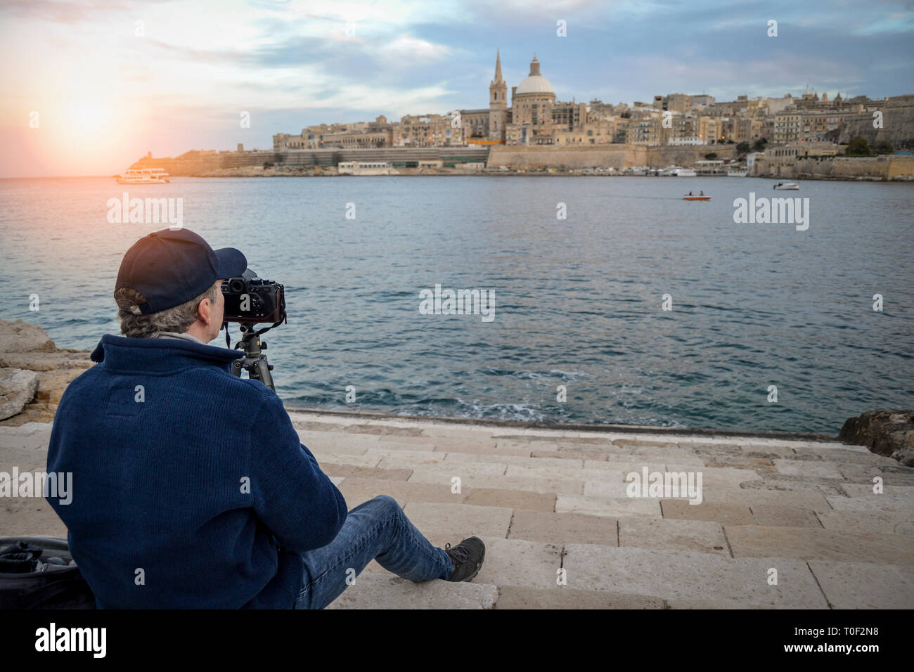 man taking landscape photos with a camera and a tripod, Valletta, Malta. Stock Photo