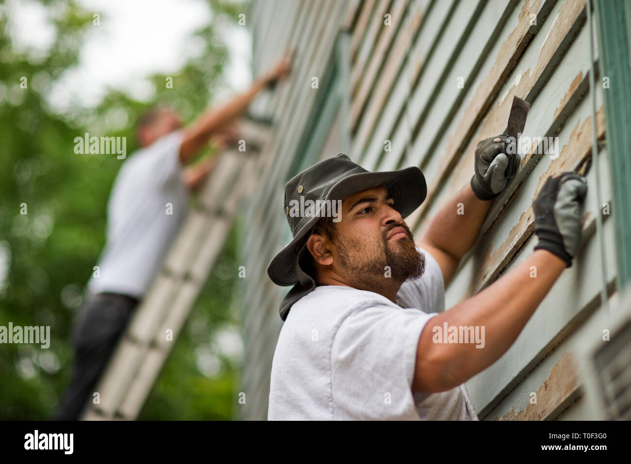 Builder sanding a piece of wood with an electric sander Stock Photo Alamy