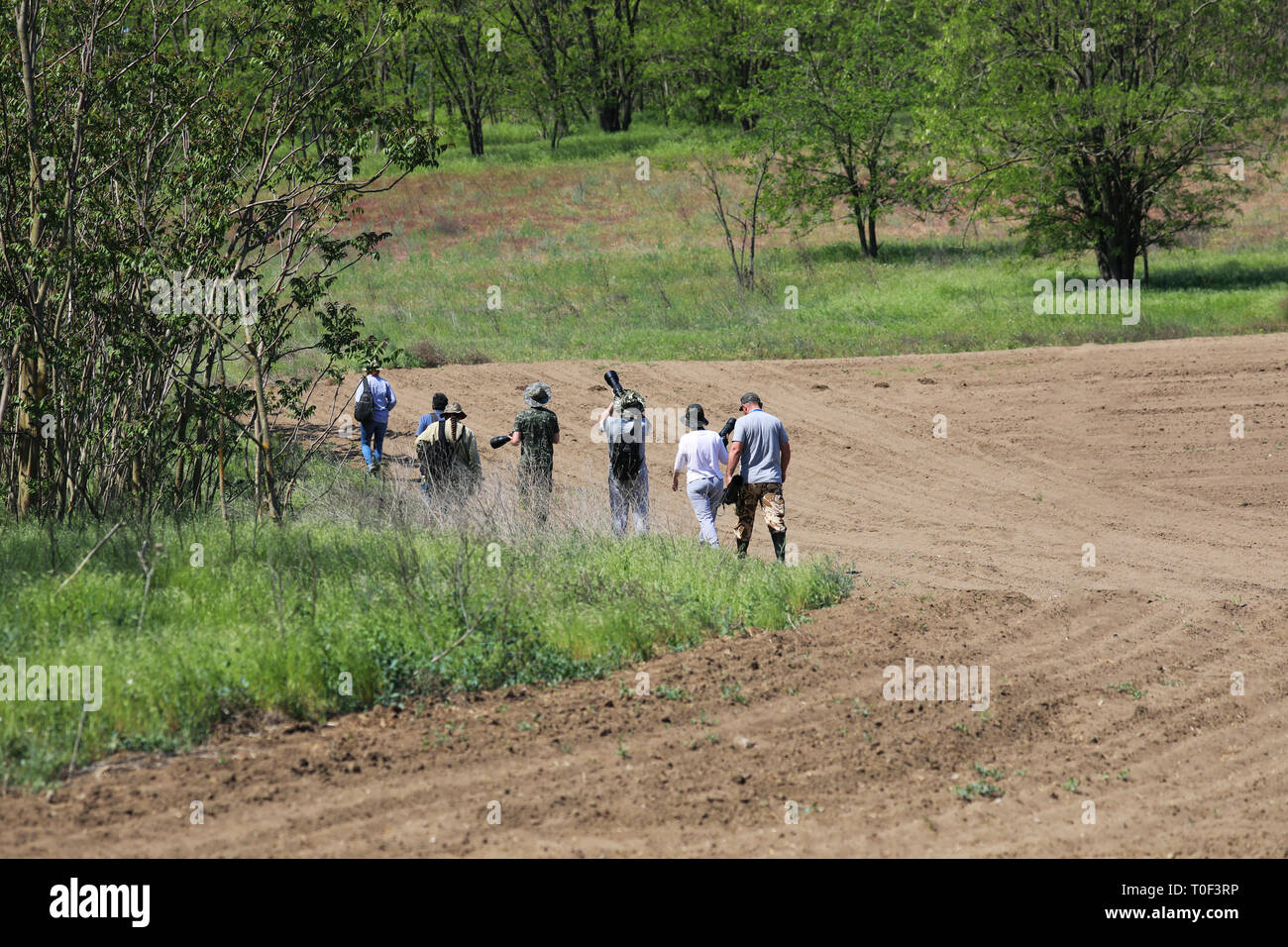 Tulcea / Romania - May 05, 2018: Group of unidentifiable photographers and birdwatchers looking for birds. Wildlife photography Stock Photo