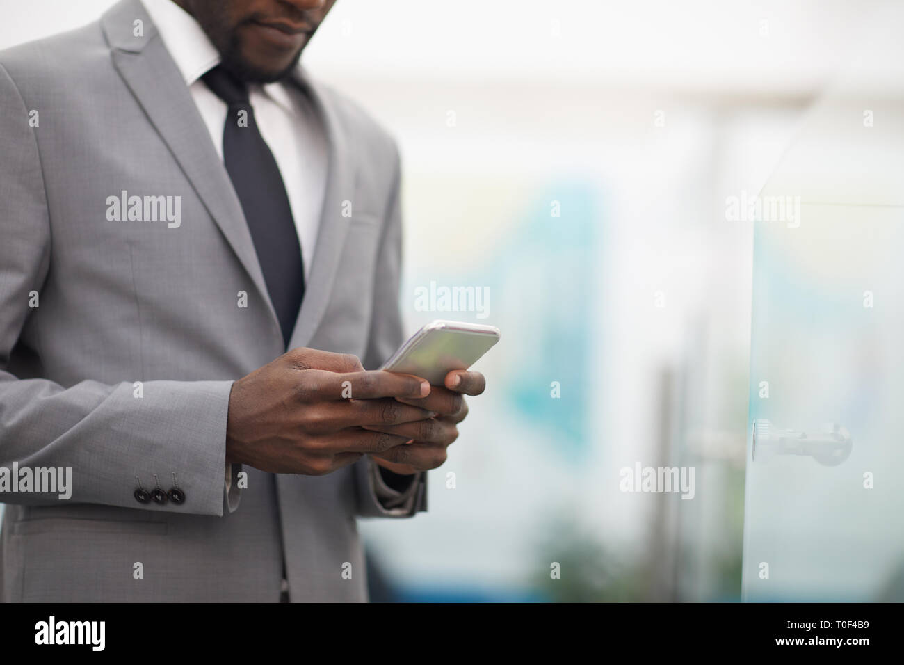African Businessman Using Smartphone Closeup Stock Photo