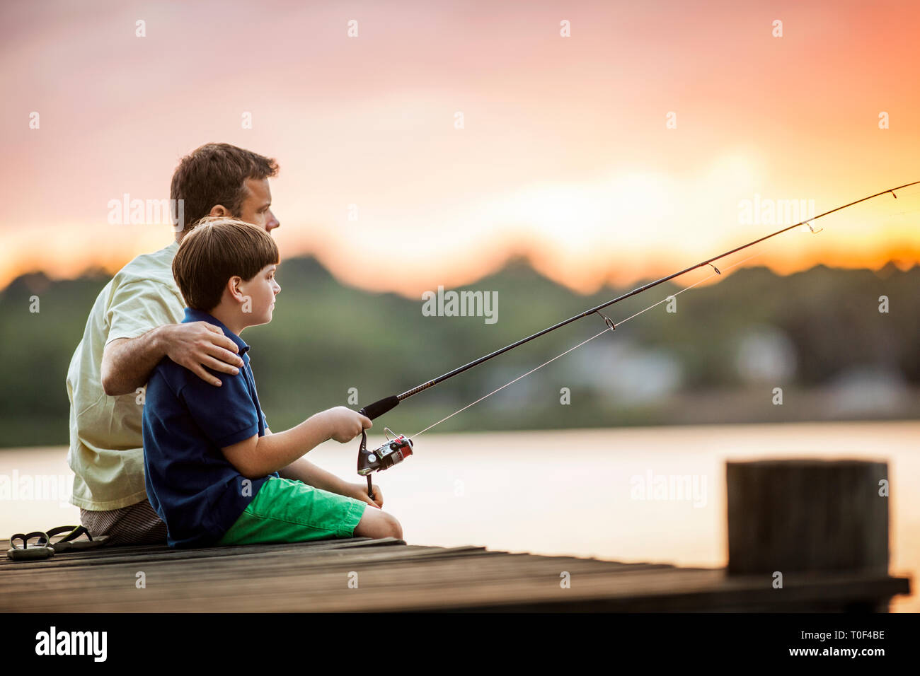 Father and son fishing from a pier Stock Photo Alamy