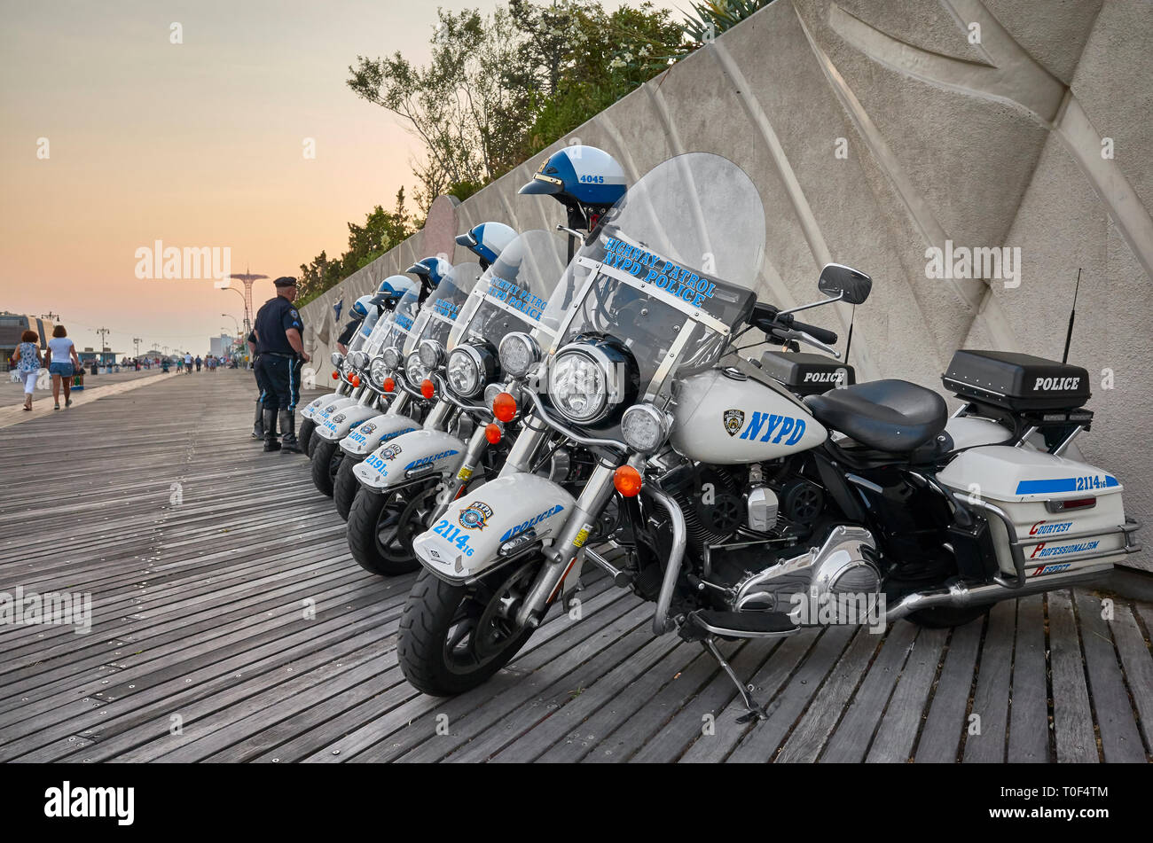 New York, USA - July 02, 2018: NYPD Highway Patrol motorcycles parked on the Coney Island beach boardwalk at sunset. Stock Photo