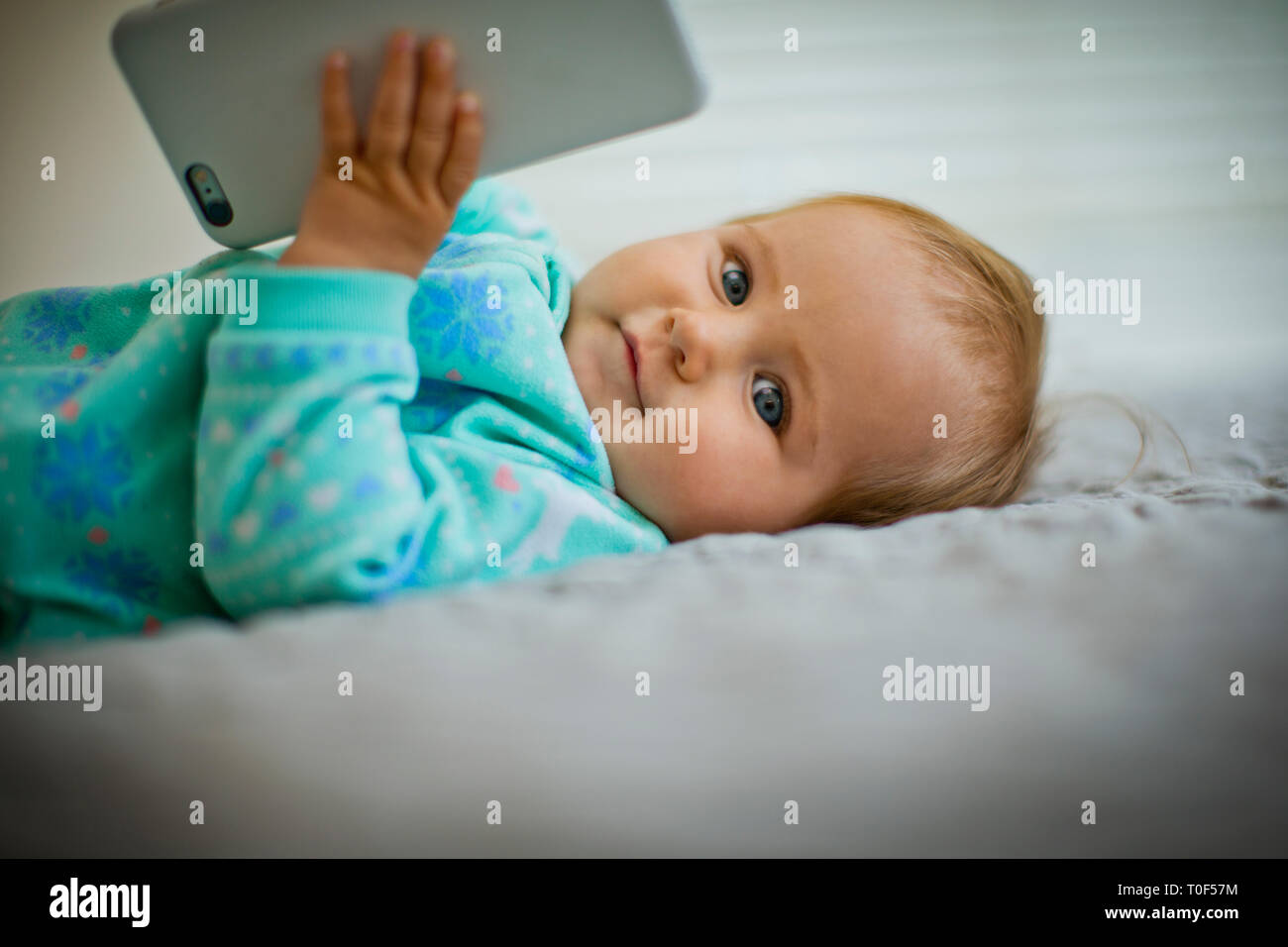 Baby girl playing with a cell phone. Stock Photo