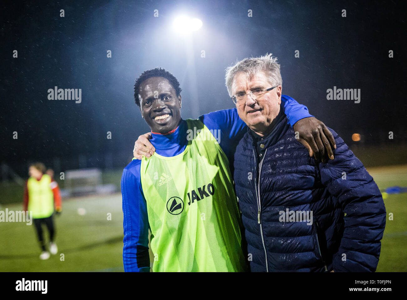 Lauchringen, Germany. 15th Mar, 2019. Kebba Manneh (l) stands together with the 1st chairman of the SC Lauchringen, Thomas Kummer at the evening training on the soccer field. (to dpa 'Fled, insulted, tolerated - honored? Kebba Manneh's story' from 20.03.2019) Credit: Christoph Schmidt/dpa/Alamy Live News Stock Photo