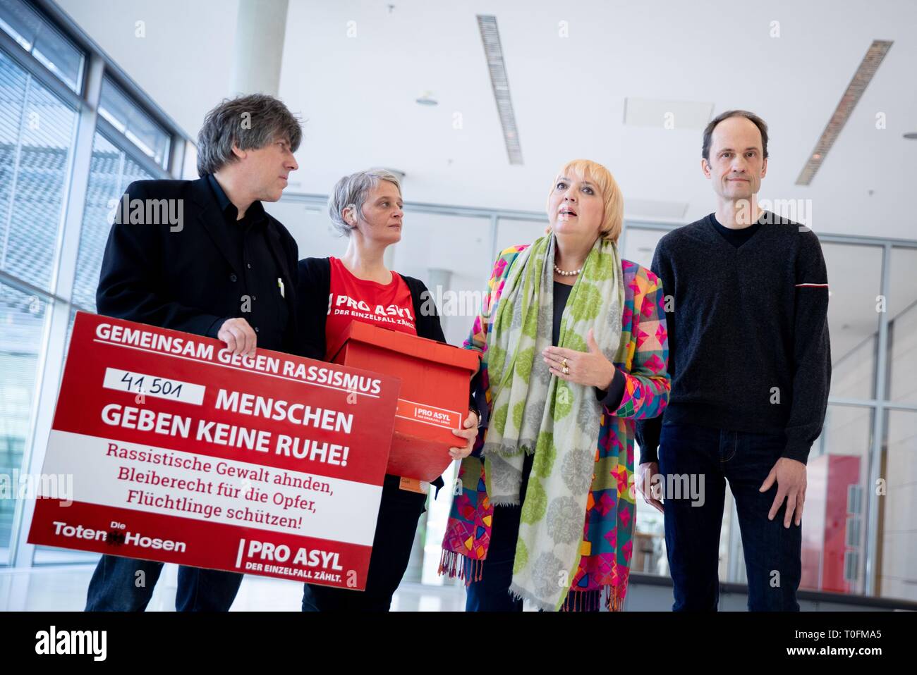 20 March 2019, Berlin: Günter Burkhardt (l-r), Managing Director of Pro Asyl, Nicole Viusa of Pro Asyl, and Michael Breitkopf of Die Toten Hosen present around 40,000 signatures against racism and refugee hostility to Claudia Roth (Bündnis90/Die Grünen), Vice President of the Bundestag, in the Bundestag. Photo: Kay Nietfeld/dpa Stock Photo