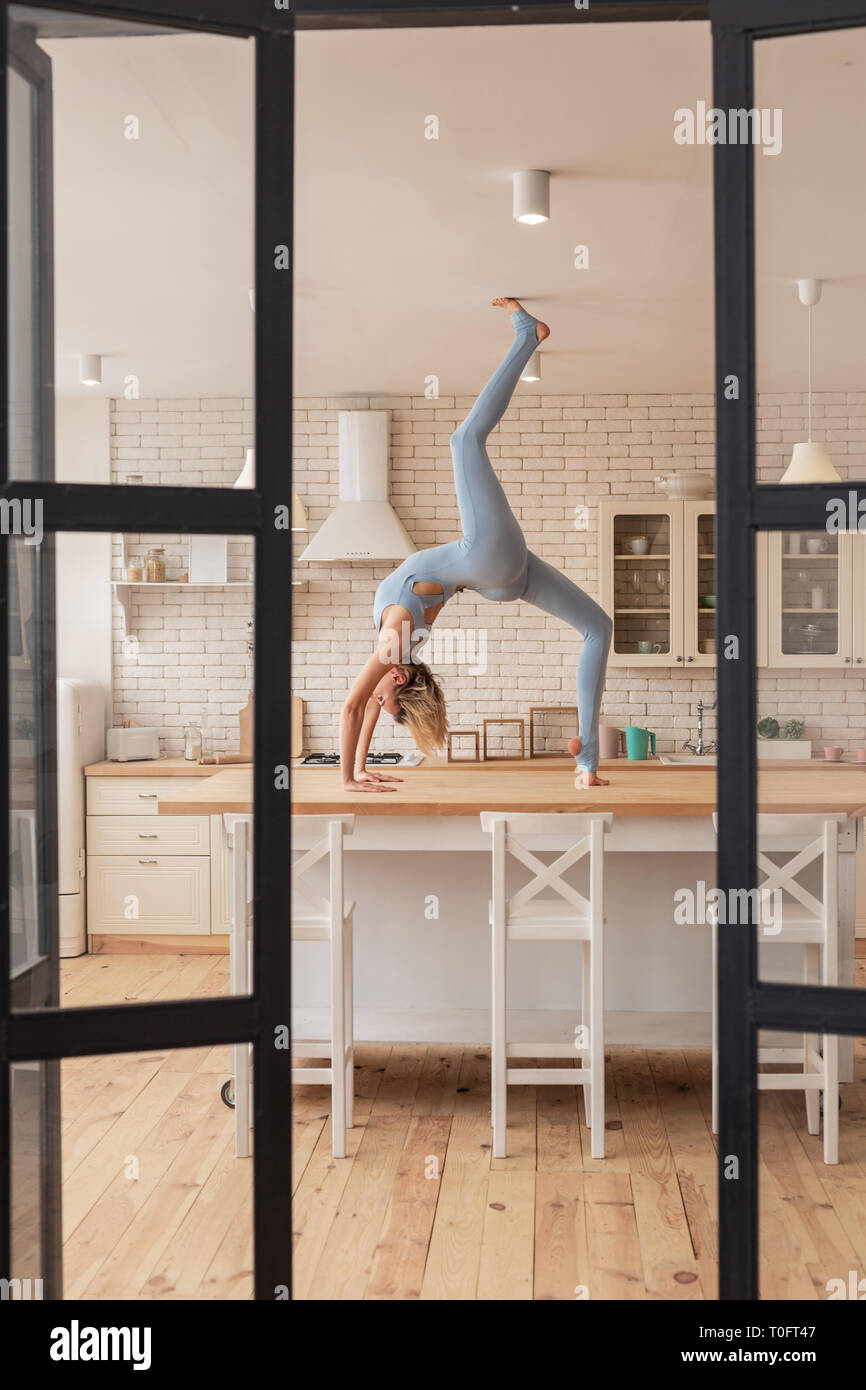 Hard-working young lady touching ceiling with her foot Stock Photo