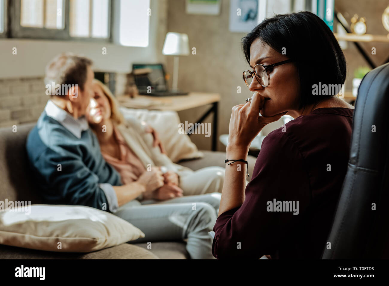 Puzzled doctor with bob haircut thinking about situation in family Stock Photo