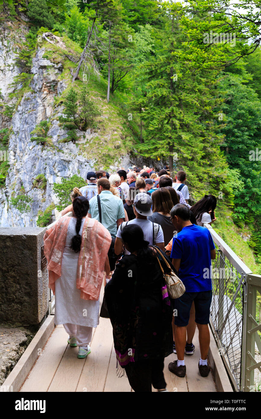 Tourists crowd onto the Marienbrucke bridge to get a view of Schloss Neuschwanstein, Munich, Bavaria, Germany Stock Photo