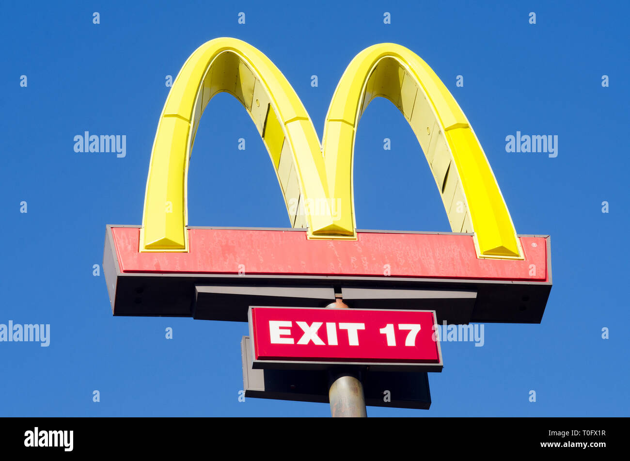 Looking up at McDonalds Golden Arches sign against a clear, deep blue sky Stock Photo