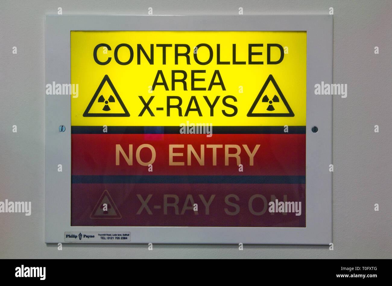 Illuminated x-ray sign showing x-rays are in progress, warning people not to enter the room. Stock Photo