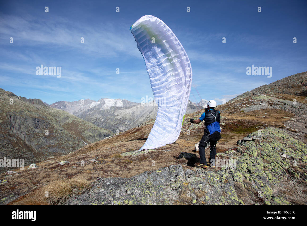 Young paraglider pilot uses his paraglider to play with the wind in the Swiss Alps, the so-called ground handling Stock Photo