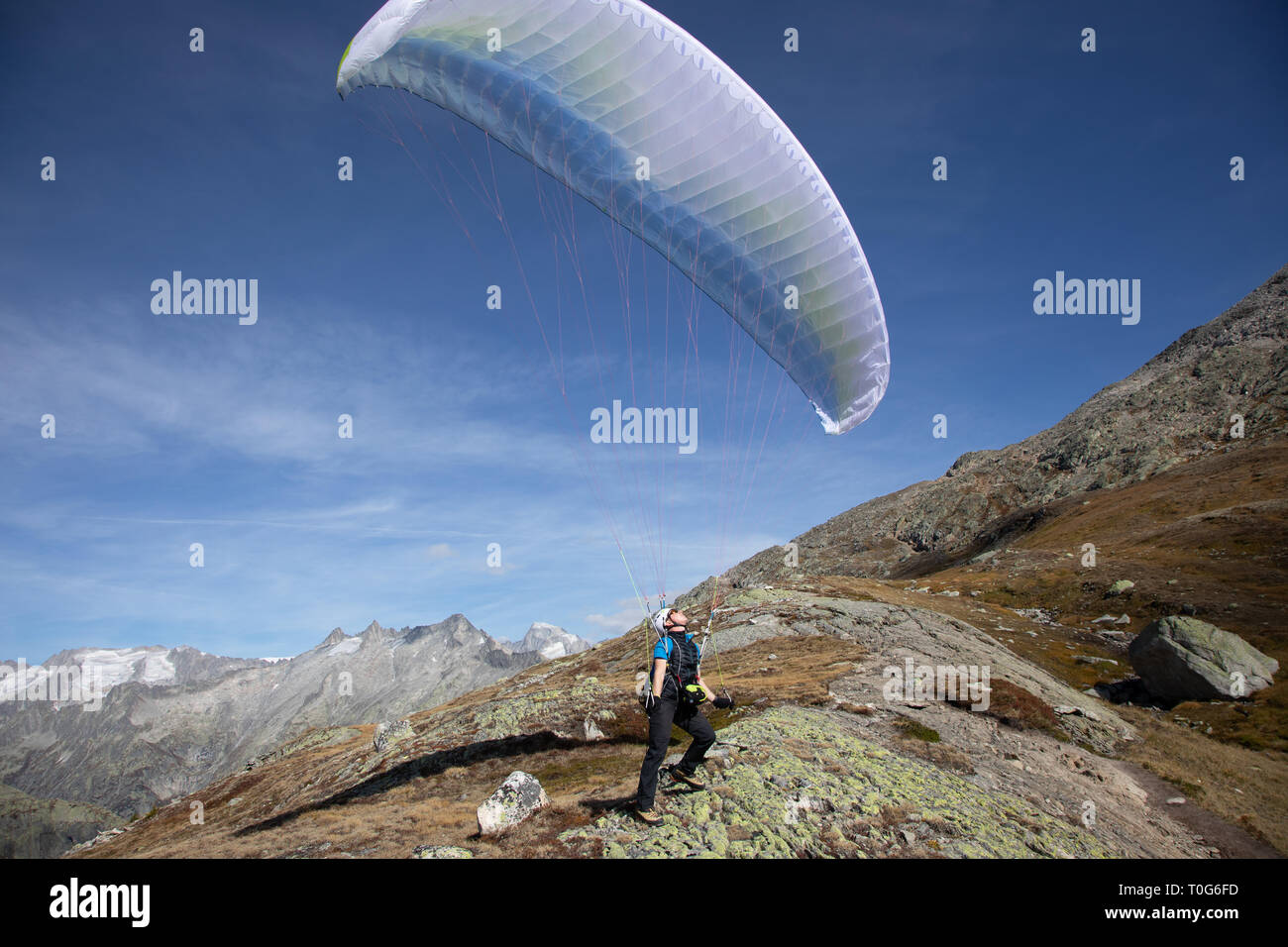 Young paraglider pilot uses his paraglider to play with the wind in the Swiss Alps, the so-called ground handling Stock Photo
