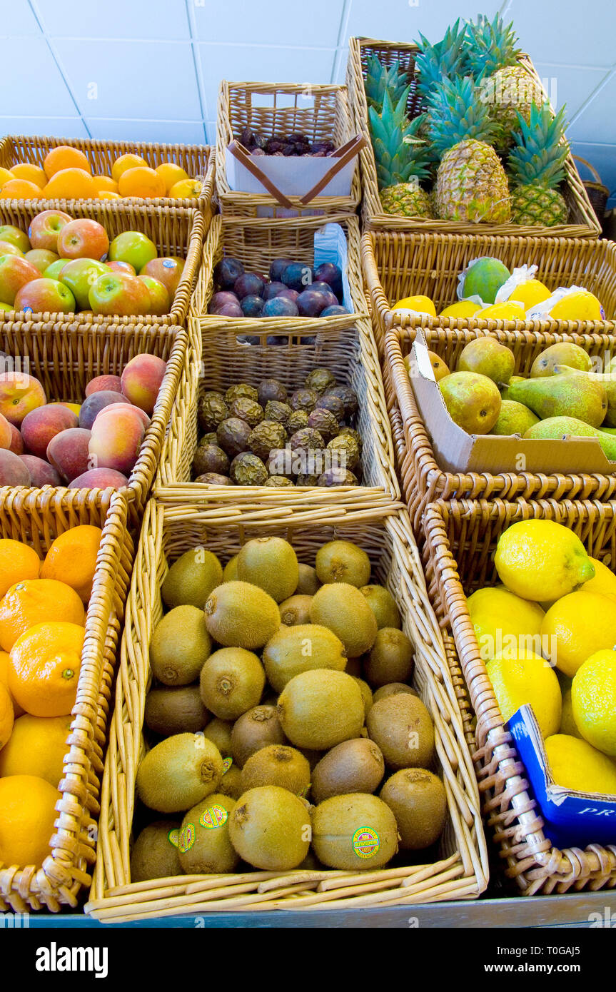 Various baskets of different fruit for sale in a green grocers. Stock Photo