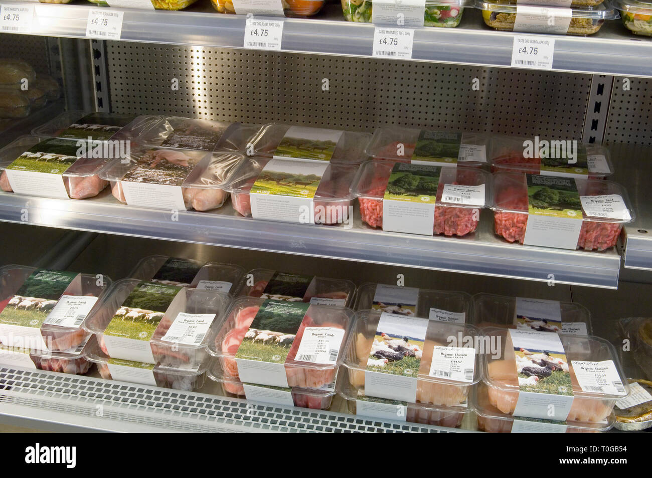 Various packets of different organic meat for sale in a shop fridge. Stock Photo