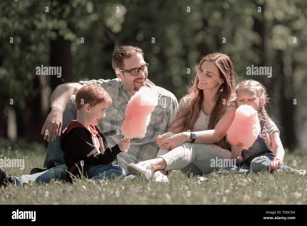 happy family resting on the lawn in the city Park Stock Photo - Alamy