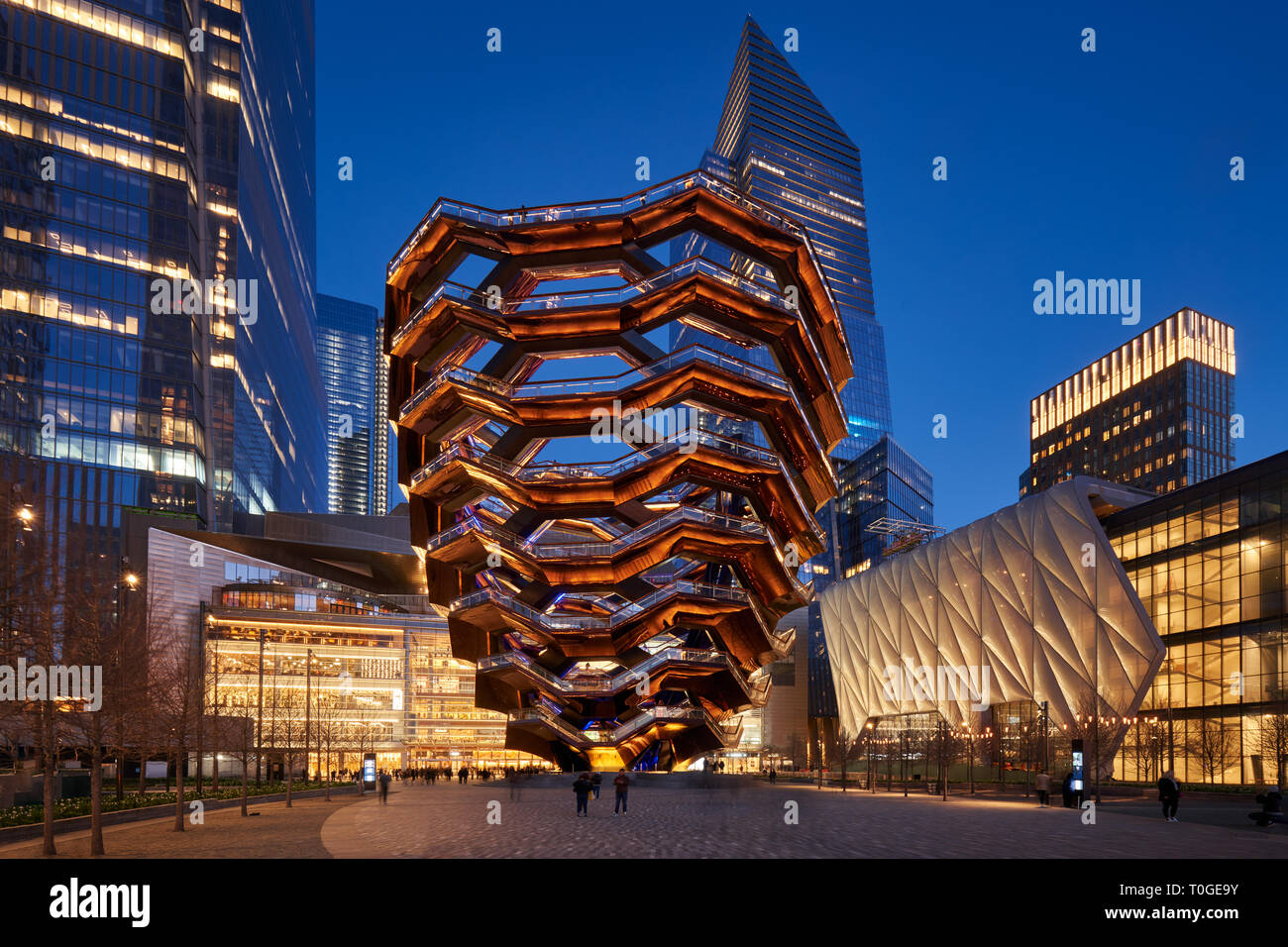The Vessel, also known as the Hudson Yards Staircase (designed by architect Thomas Heatherwick) at dusk. On the right, The Shed. Manhattan, New York Stock Photo