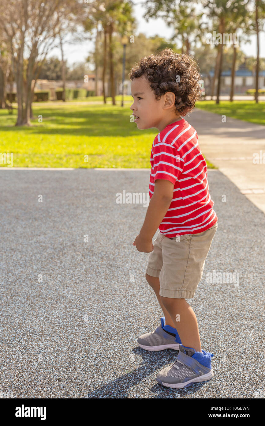 He sees the kids at the park waiting for the right moment to approach. Stock Photo