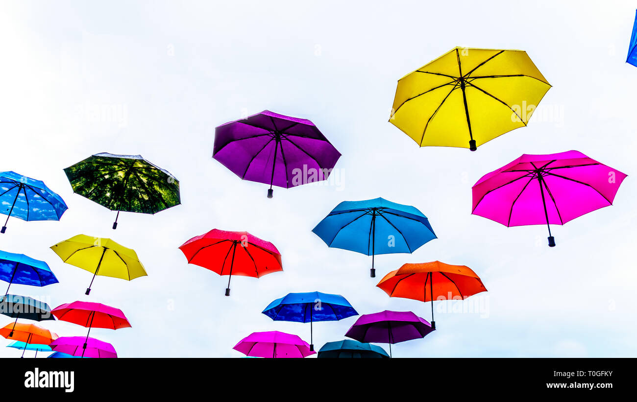 Colorful Umbrellas floating in the air under cloudy sky Stock Photo Alamy
