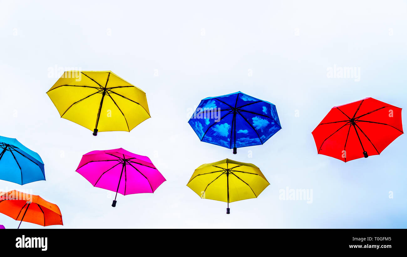 Colorful Umbrellas floating in the air under cloudy sky Stock Photo Alamy
