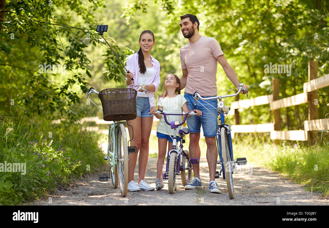 happy family with bicycles taking selfie in summer Stock Photo