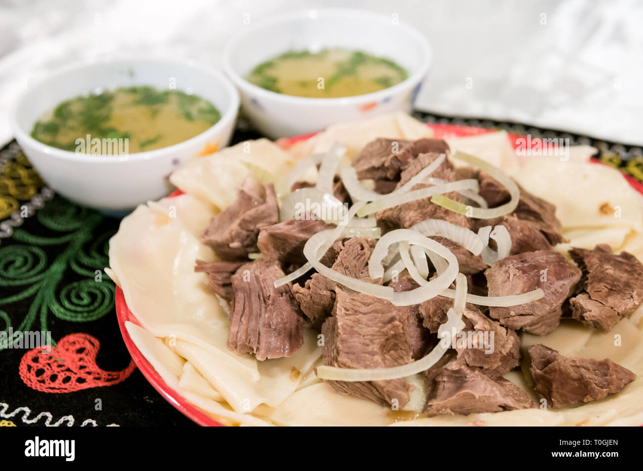 boiled meat on a plate with onion and dough Stock Photo