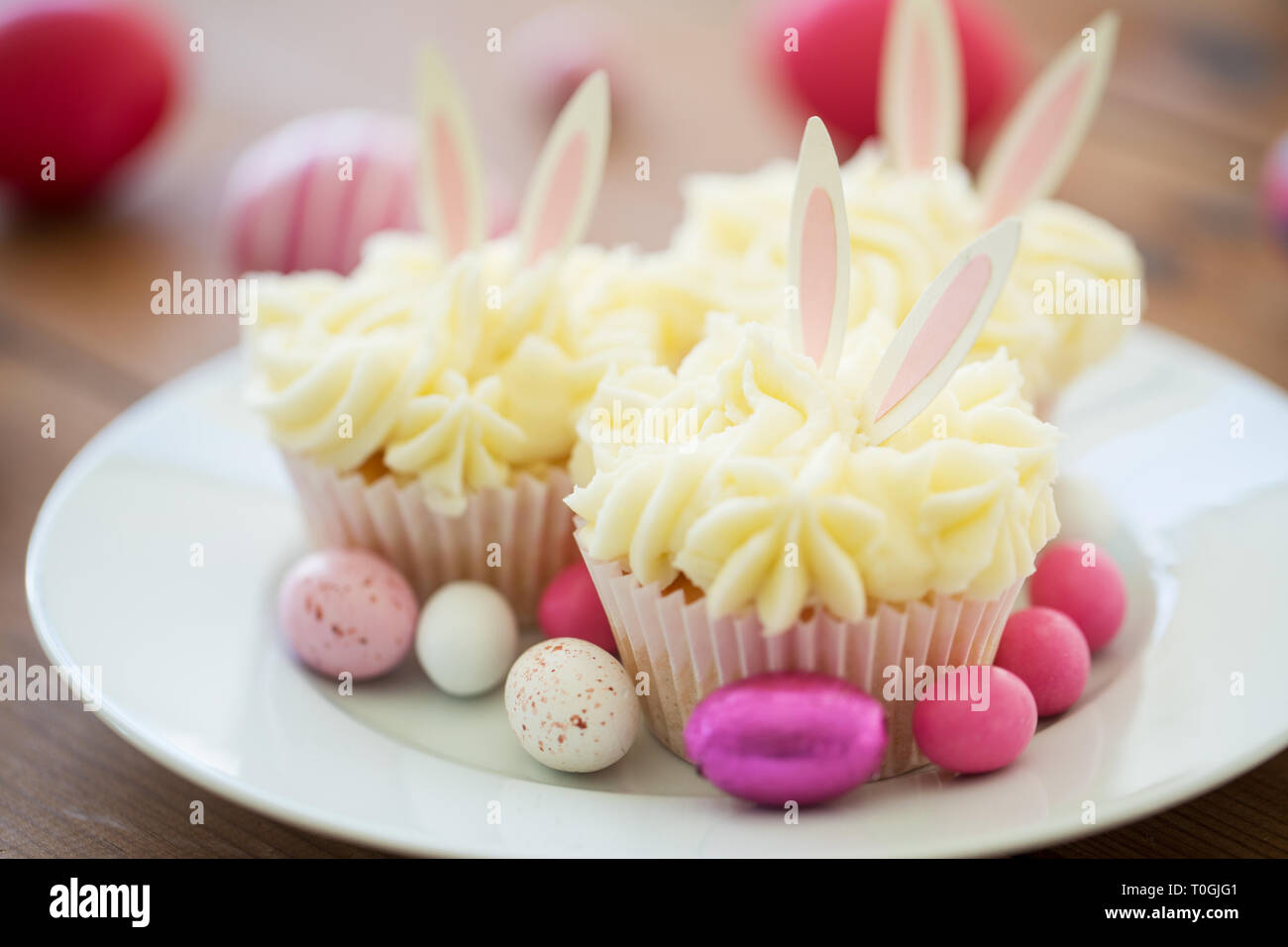 cupcakes with easter eggs and candies on plate Stock Photo