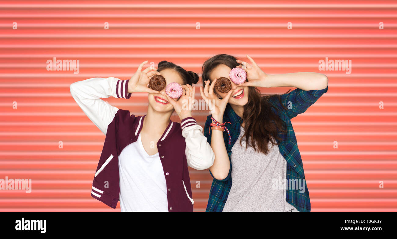 happy teenage girls or friends with donuts on eyes Stock Photo