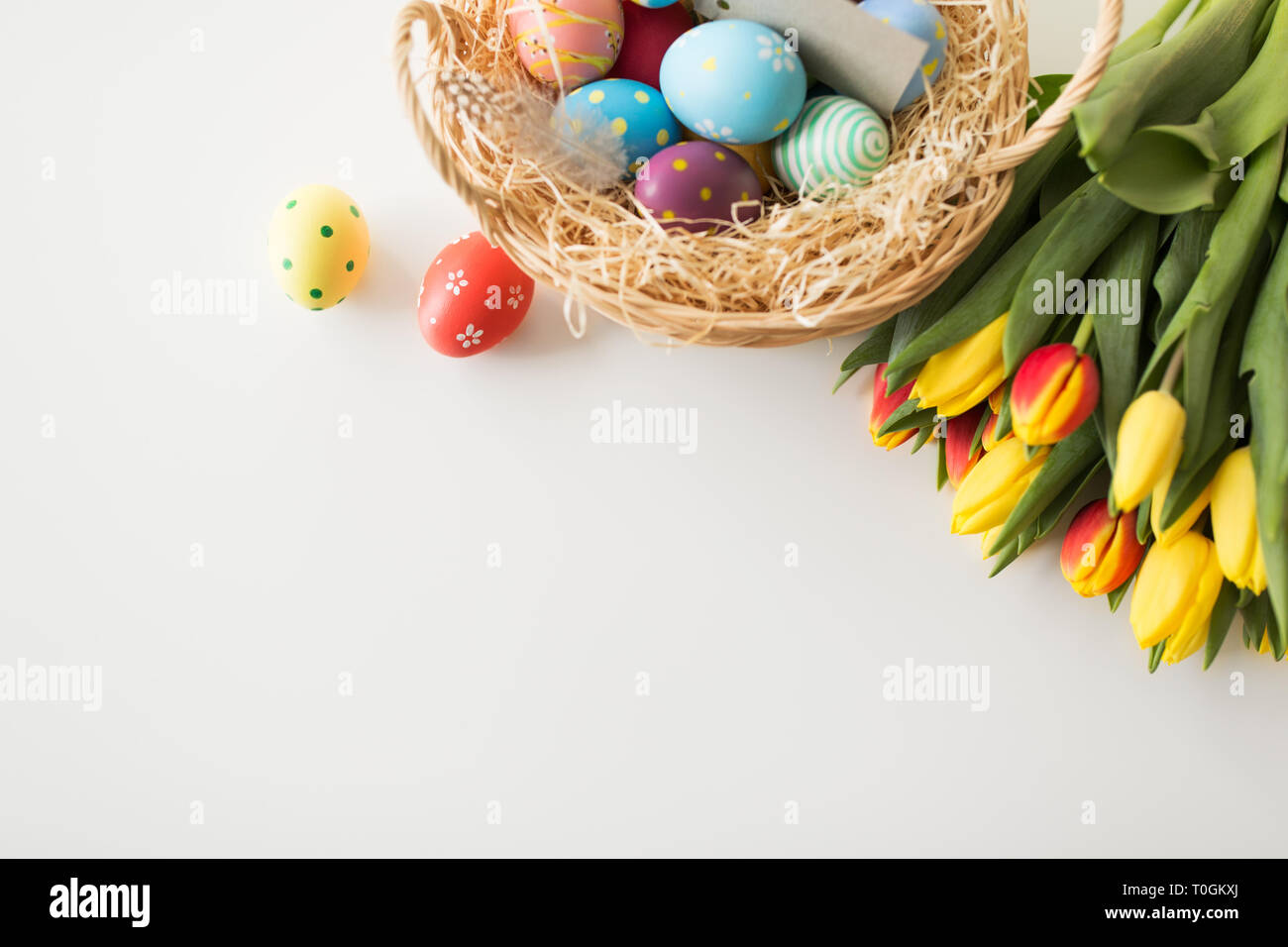 colored easter eggs in basket and tulip flowers Stock Photo - Alamy