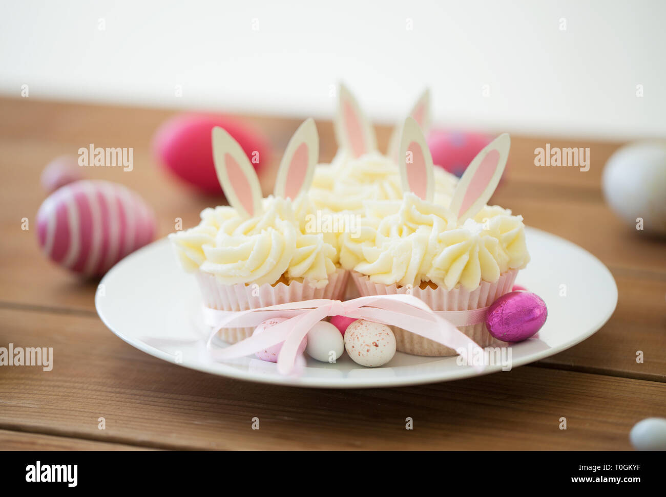 cupcakes with easter eggs and candies on table Stock Photo