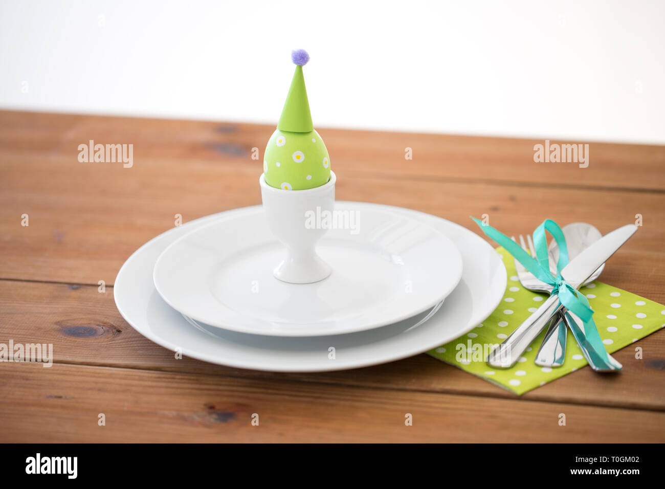 easter egg in cup holder, plates and cutlery Stock Photo Alamy