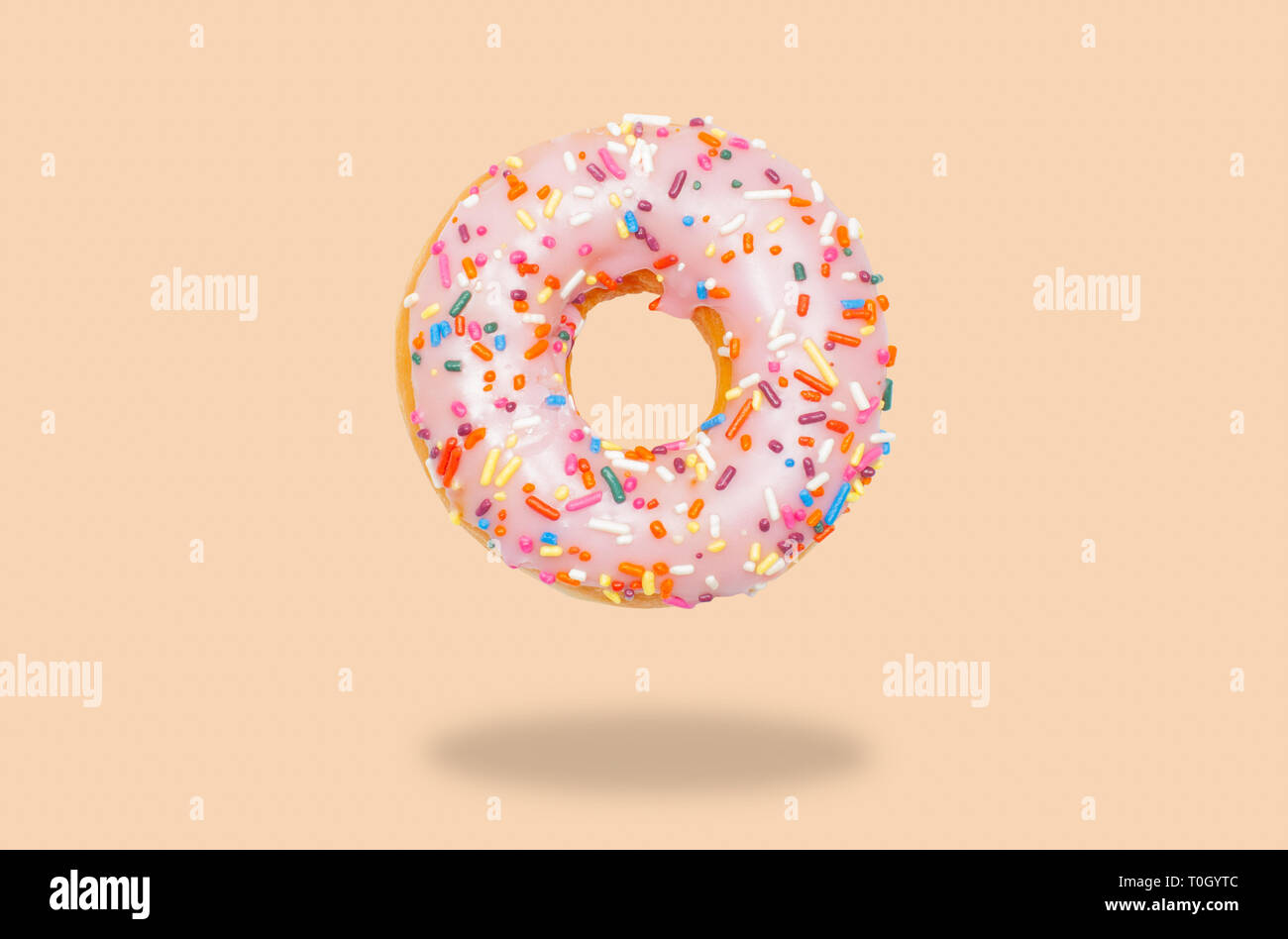 Pink donut with icing on pastel background. Stock Photo