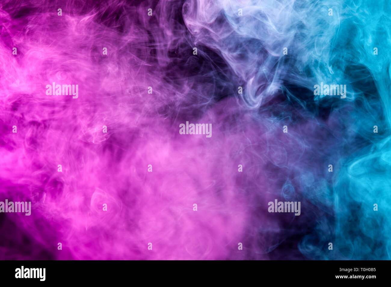 Abstract art colored pink and blue smoke on black isolated background ...