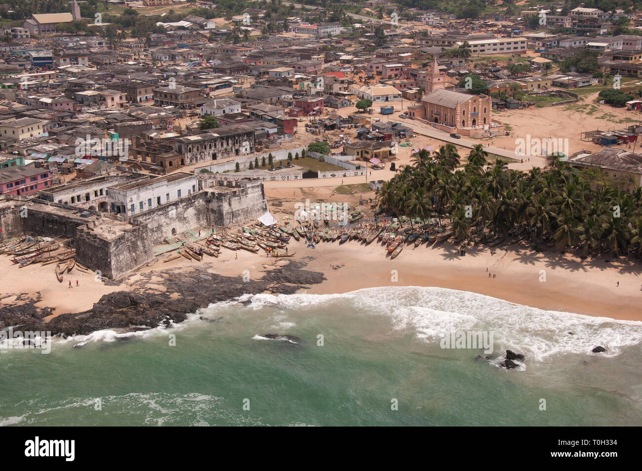 West of the city of Accra the Ghanaian coast is alive with fishing boats and people bustling around a 15th century fort. Stock Photo