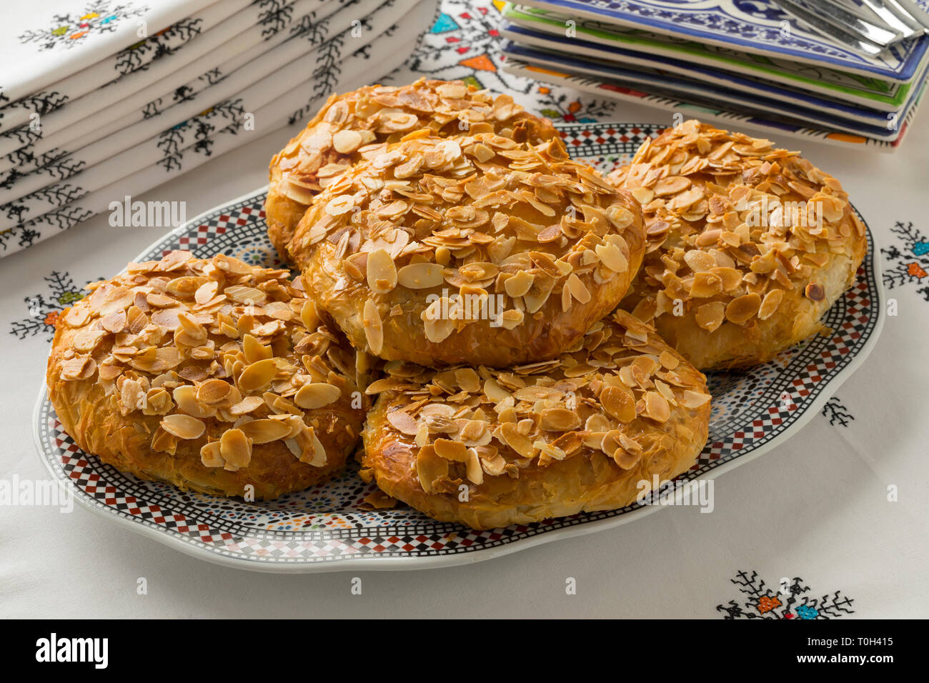 Dish with traditional Moroccan small bastella with roasted almond topping on a nice set table Stock Photo