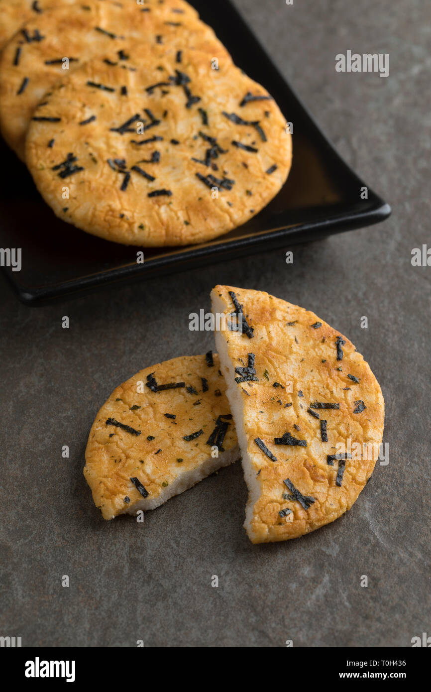 Dish with traditional whole and halved Japanese rice crackers and nori seaweed Stock Photo