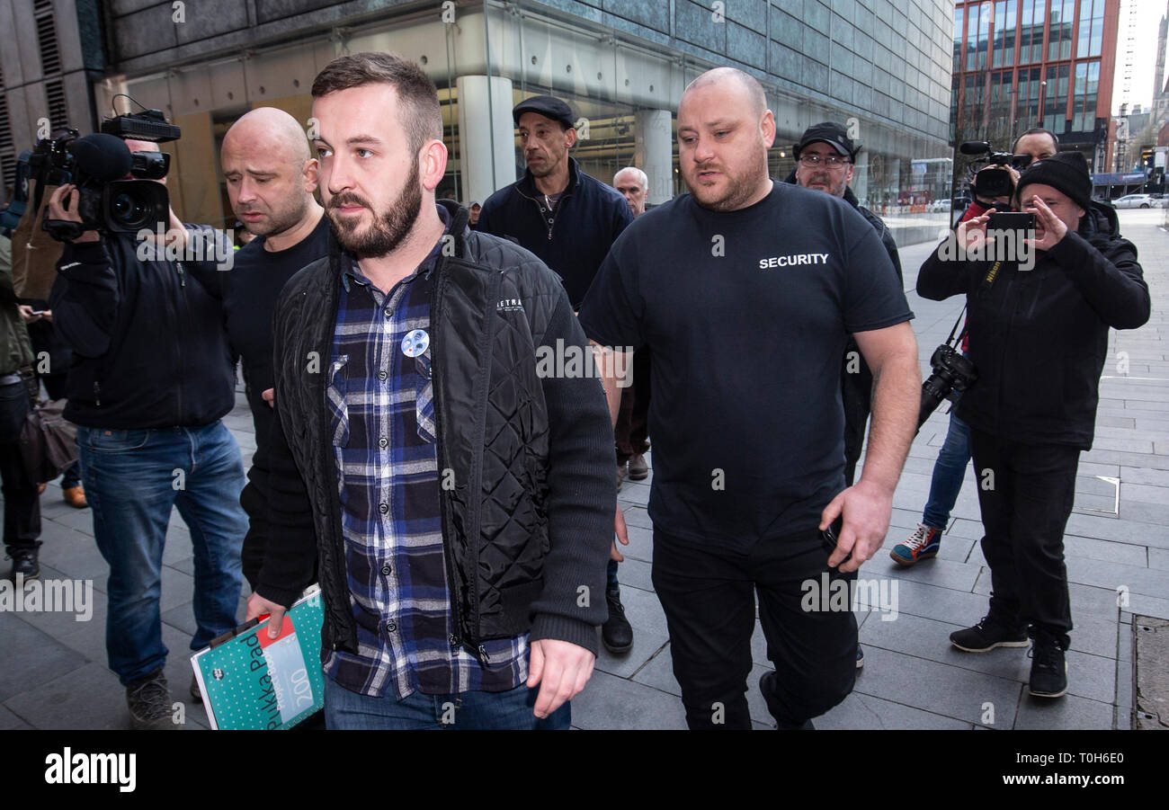 Protester James Goddard (centre) leaves Manchester Magistrates' Court, where he was charged with