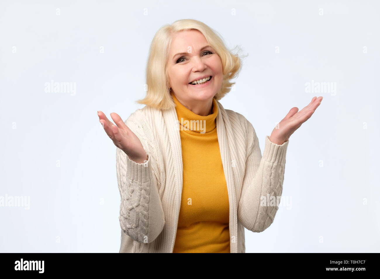 Old adult blonde excited cheerful astonished lady smiling, laughing Stock Photo